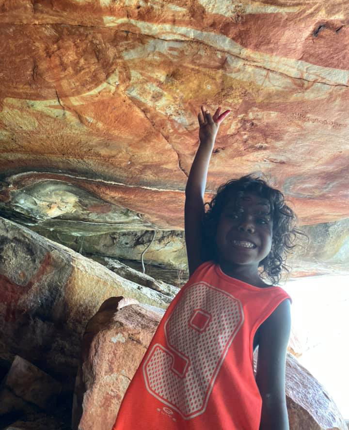 Indegenious girel pointing at Indeginous Aboriginal Rock Art